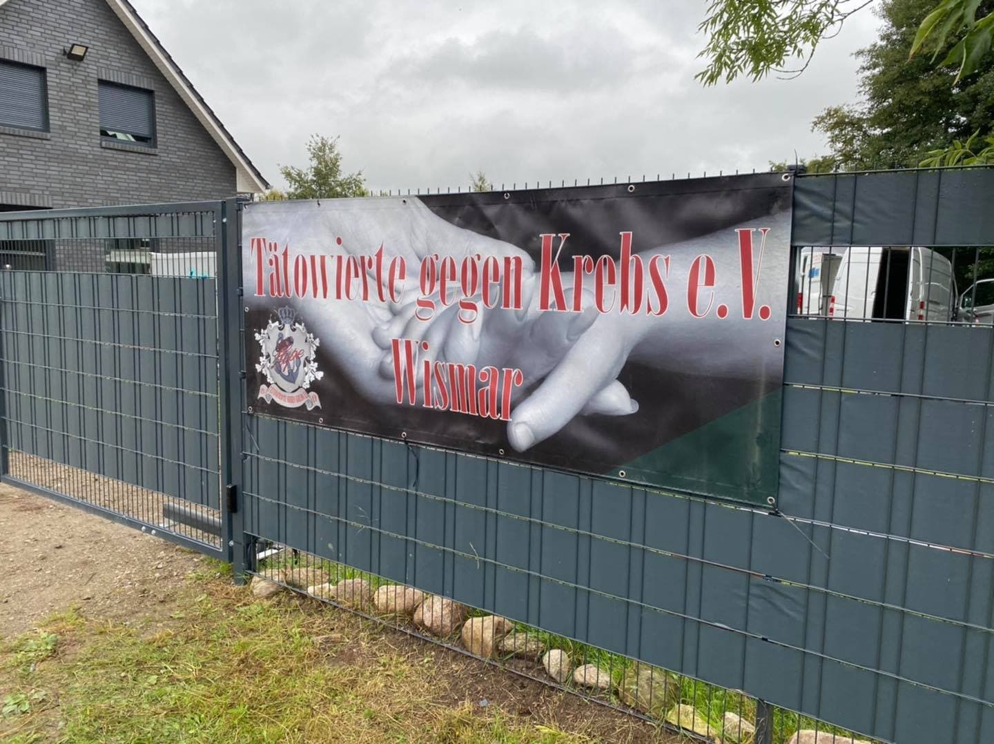 Gruppenbild mit Spendenscheck vor einem Gebäude